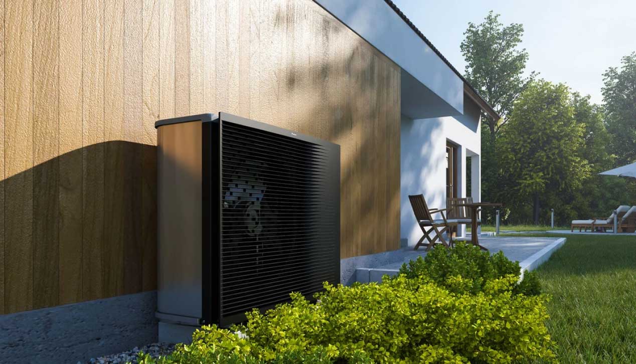 EIne Wärmepumpe vor einer Mauer im Garten